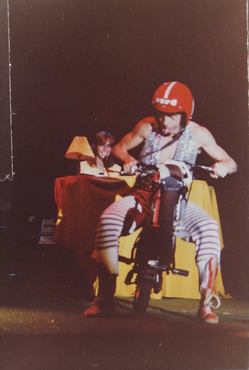 Jahn Teigen med rød hjelm sittende på moped